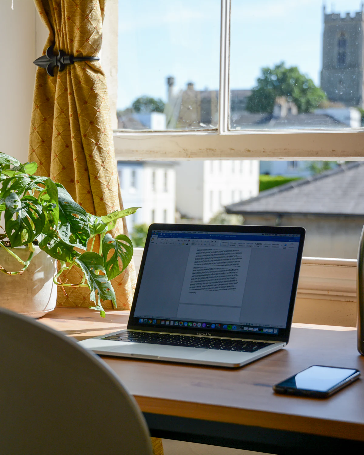 Laptop on a desk by a window